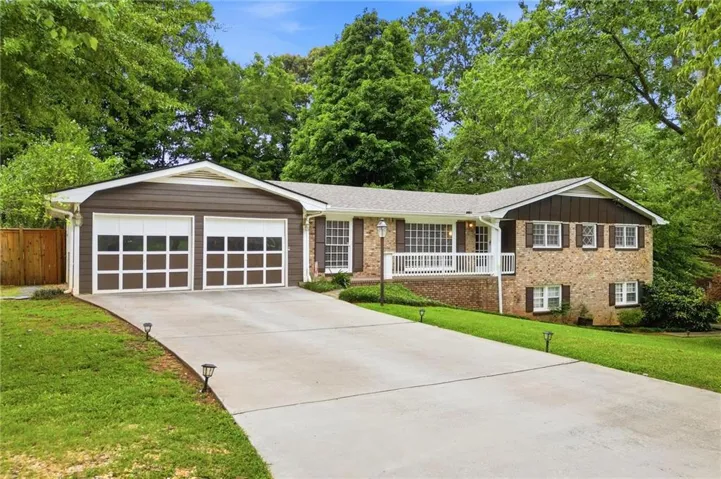 Brick and siding exterior featuring a two-car garage with glass-paneled doors