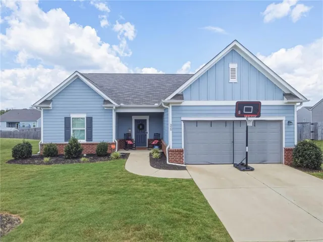 Light blue siding exterior with brick accents and a dark shingle roof