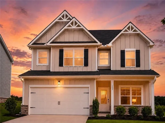 Warm, serene, and inviting, this stunning Dayton E showcases timeless farmhouse elegance with dramatic gables, crisp white board-and-batten siding, bold black shutters, glowing windows, and a breathtaking sunset backdrop that creates unforgettable curb appeal.