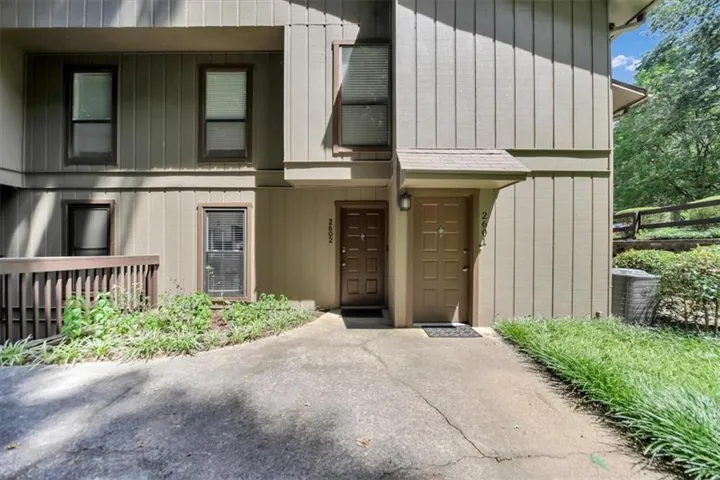 Exterior featuring vertical panel siding, multiple windows, and a covered entry