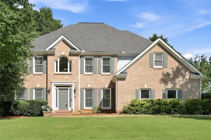 Brick-front exterior featuring a gabled roofline and a neutral color palette