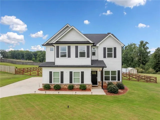 Two-story residence featuring white siding and black shutters