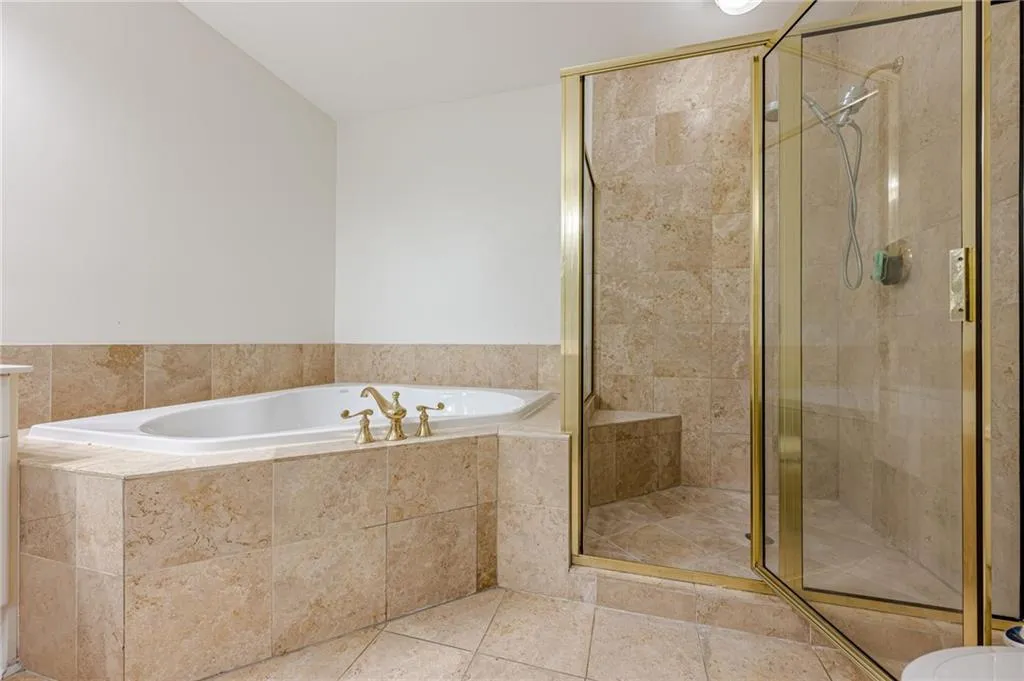 Bathroom with a bath, a stall shower, and tile patterned flooring