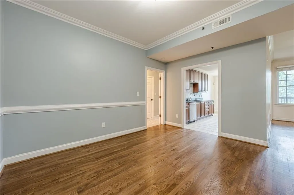 Empty room featuring ornamental molding and wood finished floors