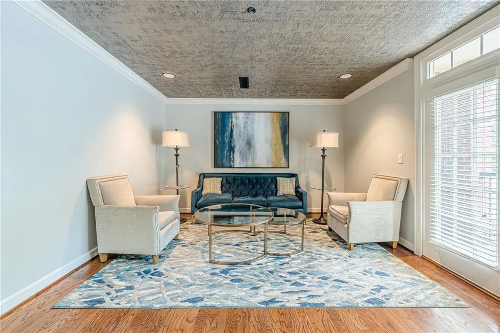 Living room with ornamental molding, wood finished floors, and recessed lighting