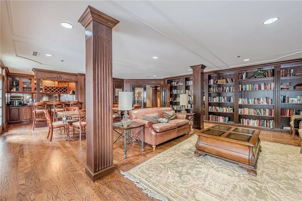 Living area featuring ornate columns, light wood-style floors, and recessed lighting