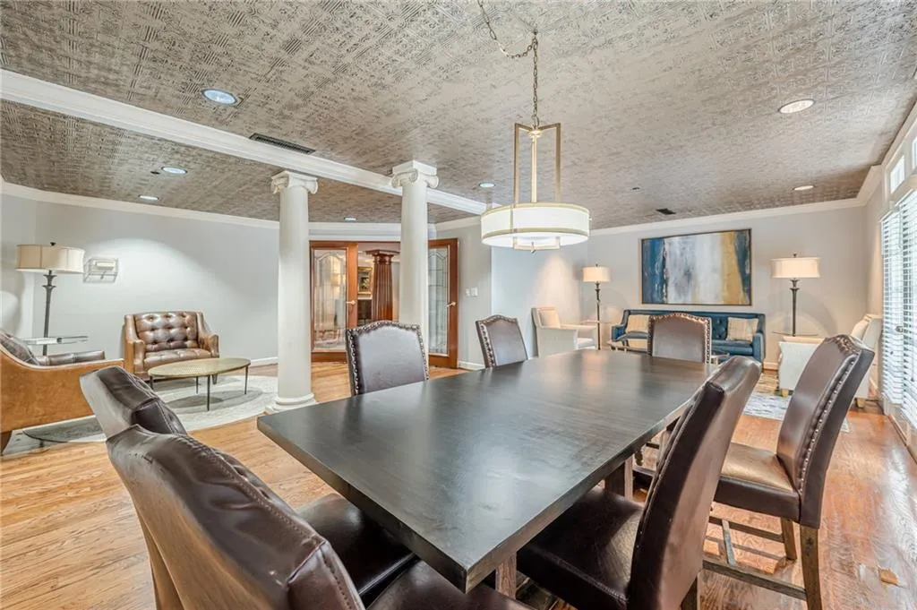 Dining room with decorative columns, wood finished floors, ornamental molding, and recessed lighting