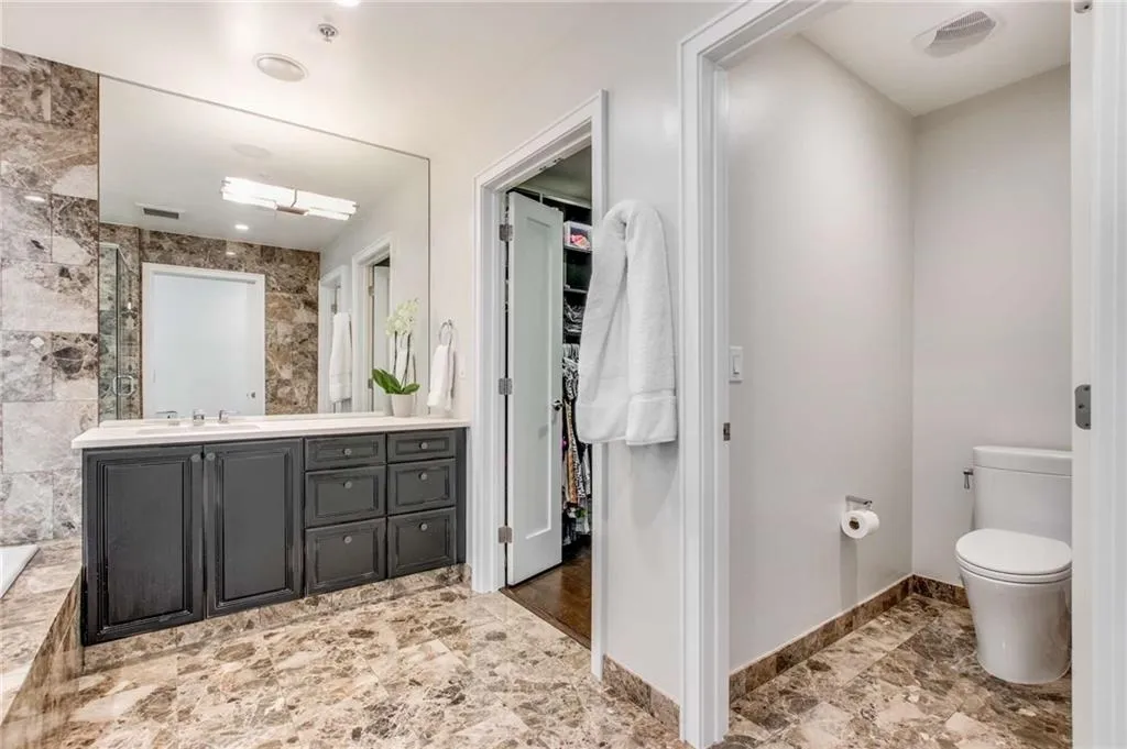 Bathroom with vanity, a walk in closet, and tile walls
