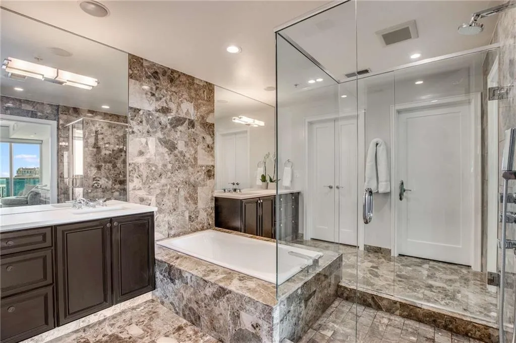 Full bathroom with vanity, a garden tub, a shower stall, and tile walls
