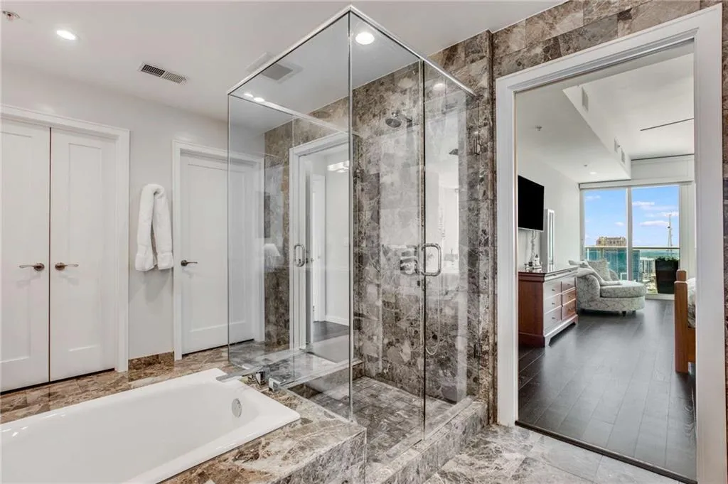 Ensuite bathroom featuring recessed lighting, a shower stall, and a garden tub