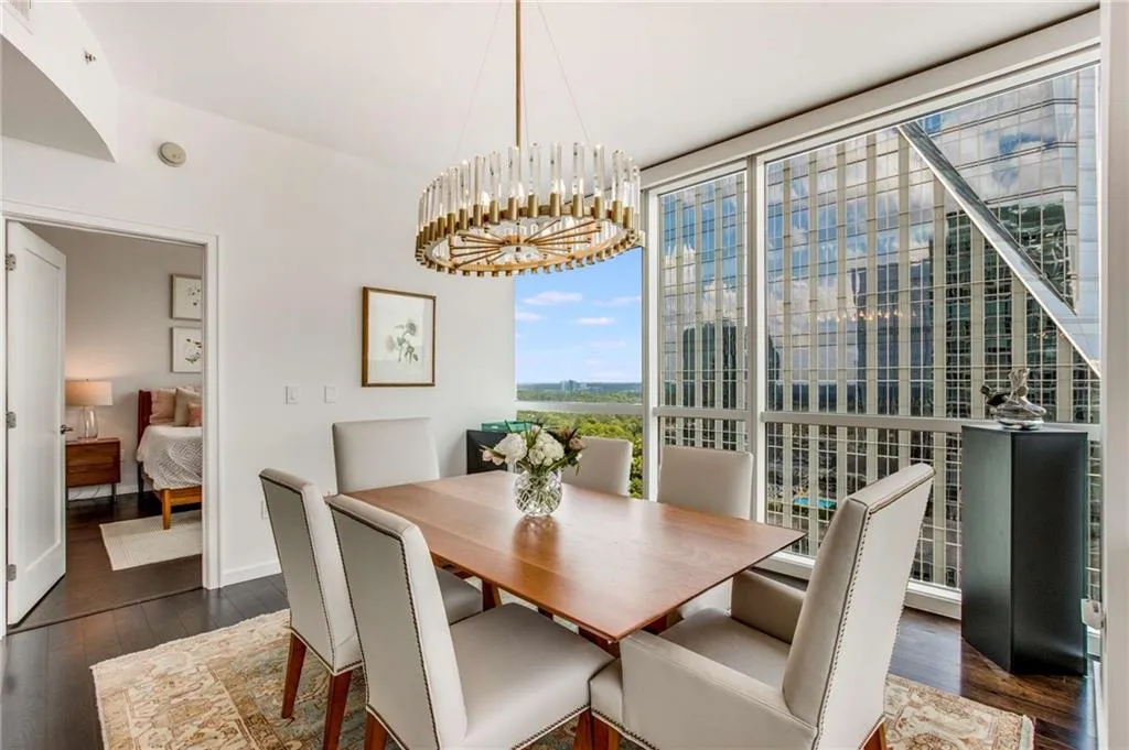 Dining space with dark wood finished floors, a chandelier, and floor to ceiling windows