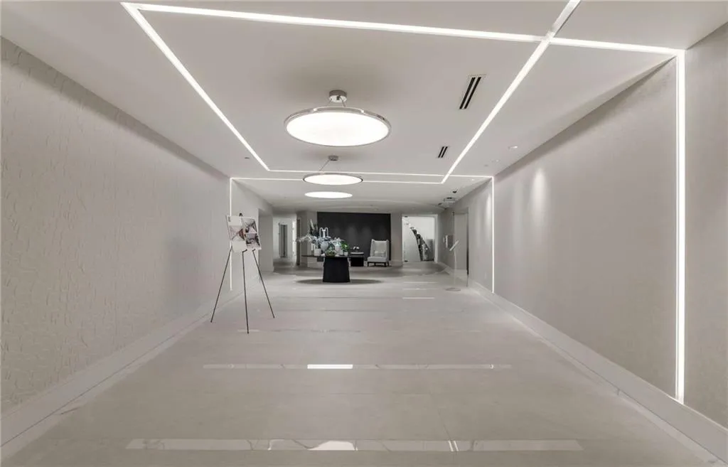 Hall featuring a textured wall and baseboards