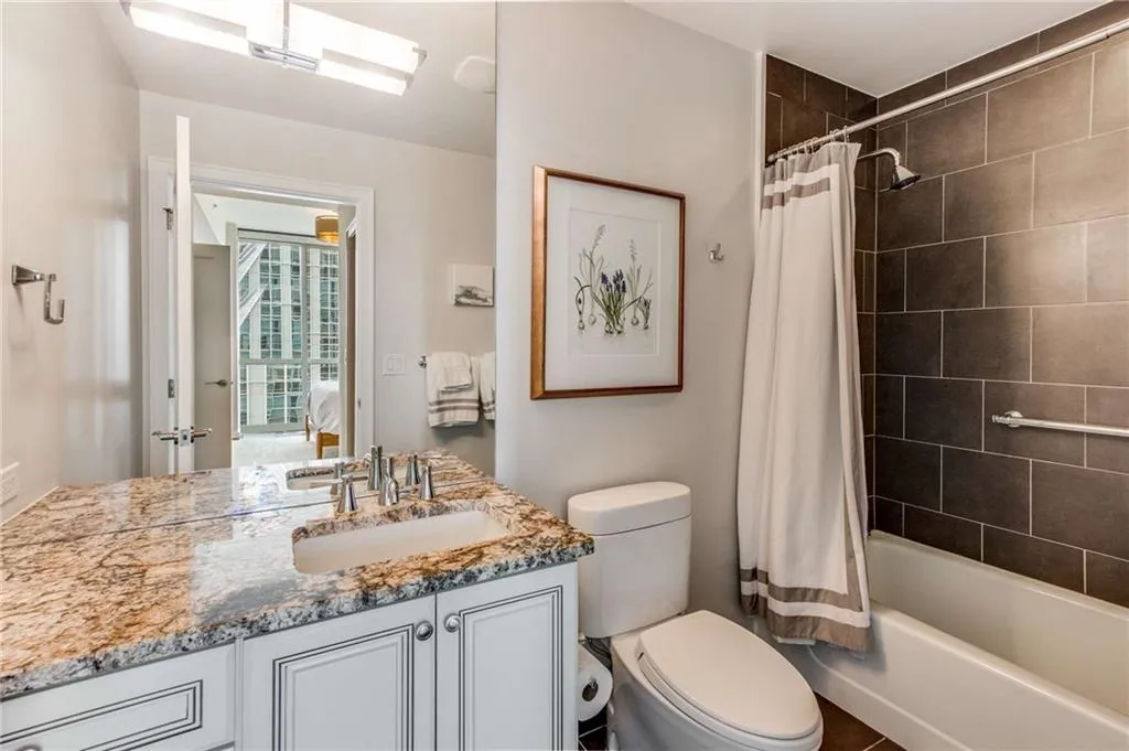 Full bath with shower / bathtub combination with curtain, vanity, and ensuite bathroom