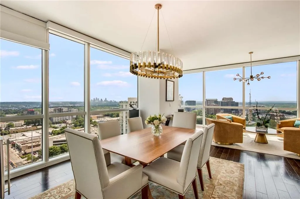 Dining space with a chandelier, a city view, expansive windows, and dark wood-style flooring