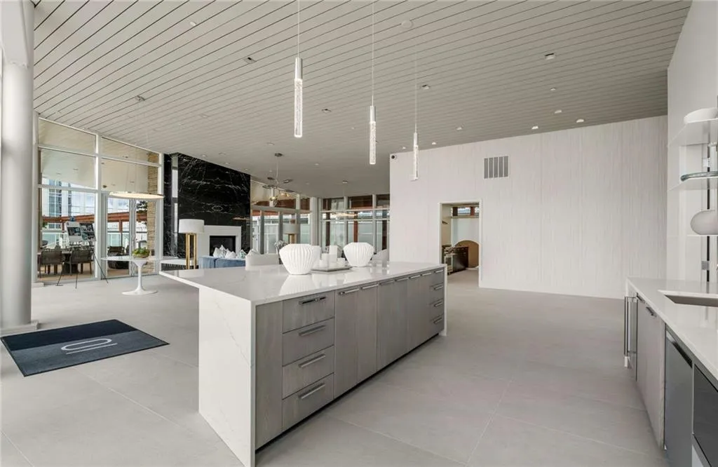 Kitchen featuring a wall of windows, modern cabinets, light stone counters, open floor plan, and a center island