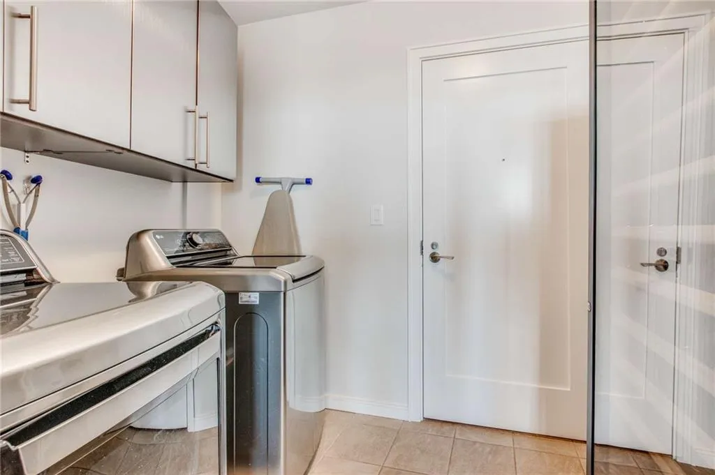Laundry area featuring cabinet space, independent washer and dryer, and light tile patterned floors