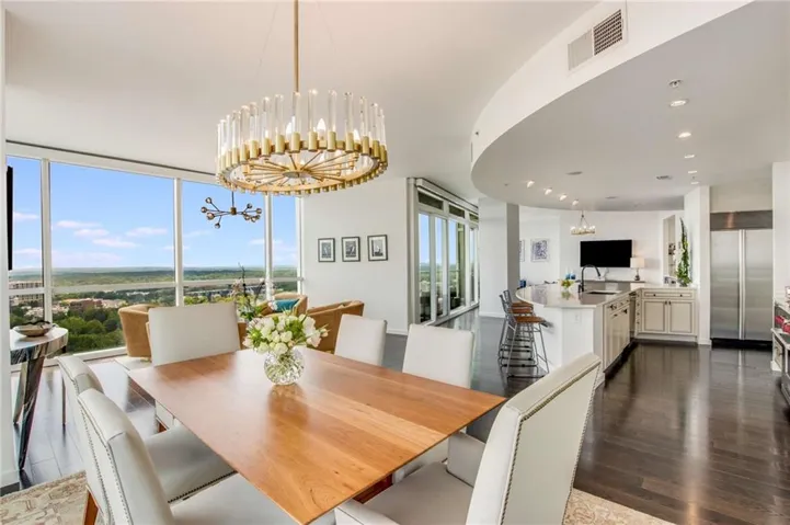 Dining room featuring a chandelier, expansive windows, dark wood-style flooring, and recessed lighting