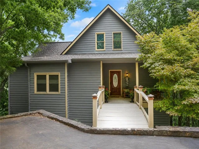 Two-story exterior with horizontal siding, covered entry porch, and a wood-finish front door with an oval glass insert