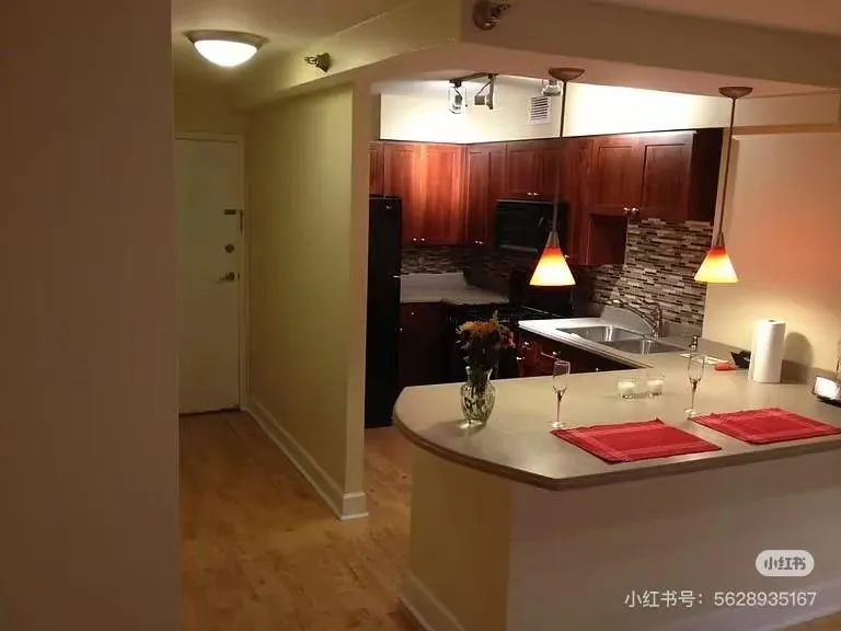 Kitchen featuring backsplash, light countertops, black appliances, a peninsula, and light wood-type flooring