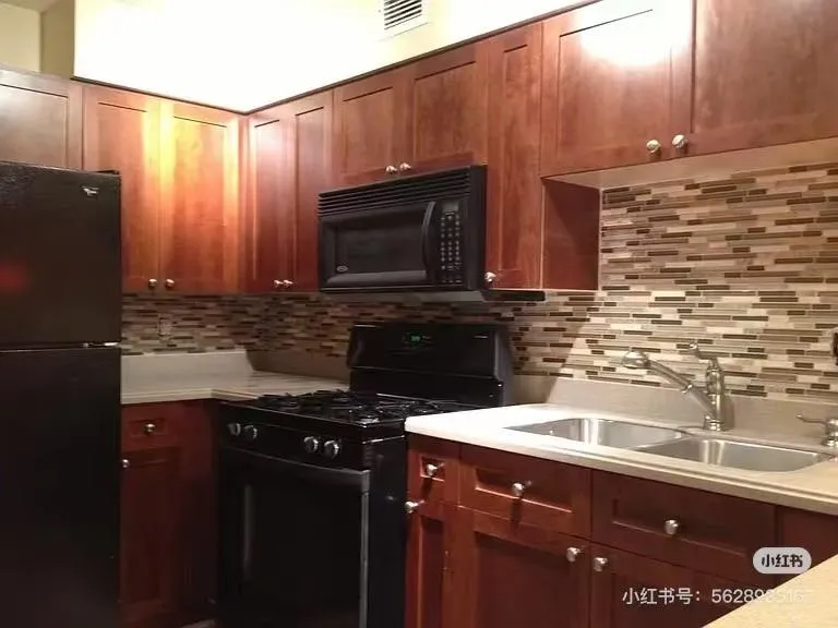 Kitchen with black appliances and tasteful backsplash