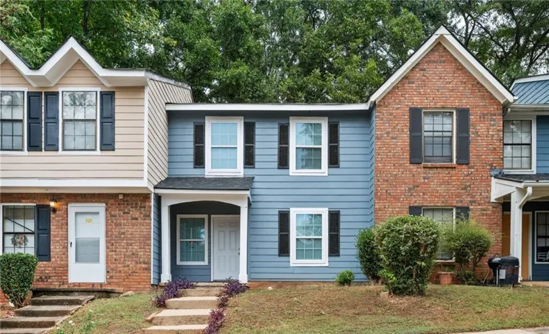 Two-story townhome featuring blue siding and a covered front entry