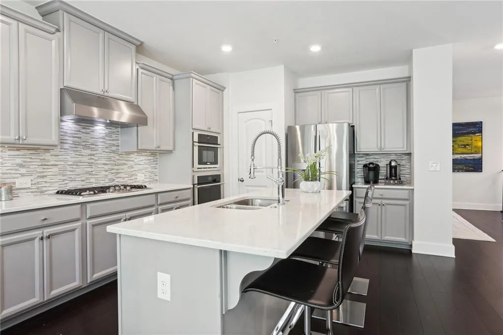 Completely renovated kitchen with island, gorgeous backsplash, fossilized bamboo floors and stainless steel appliances.