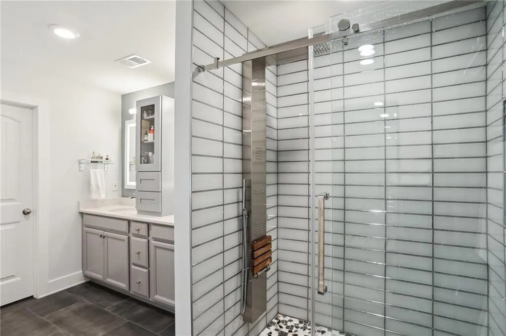 Primary Bathroom featuring tile floors, vanity, and a large shower