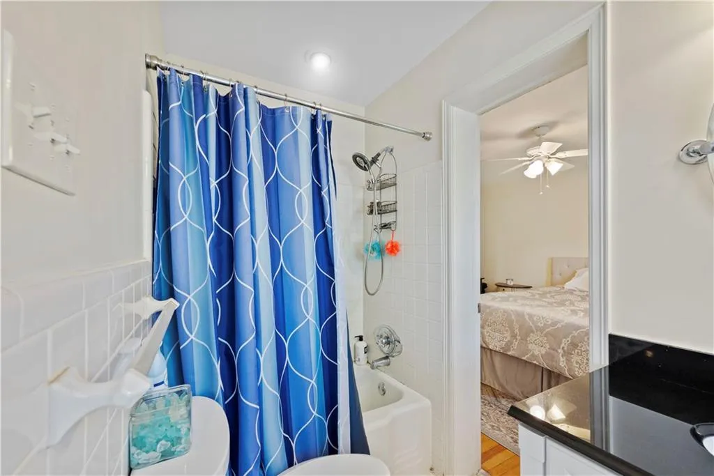 Full bathroom featuring connected bathroom and shower / bath combination with curtain