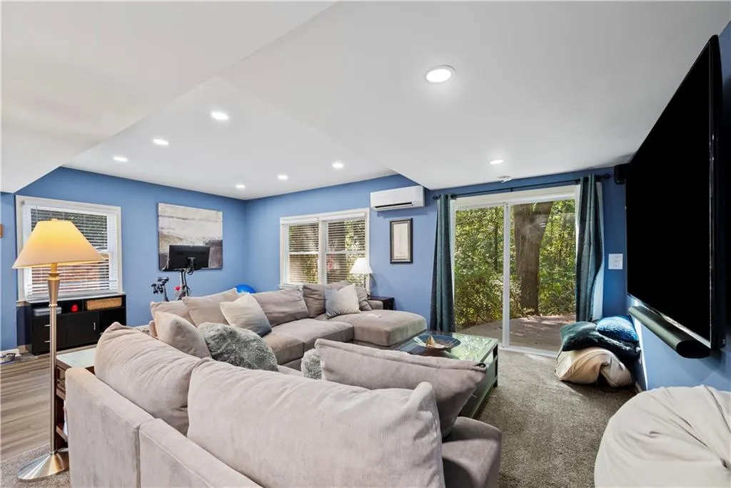 Living room with recessed lighting and a wall mounted air conditioner