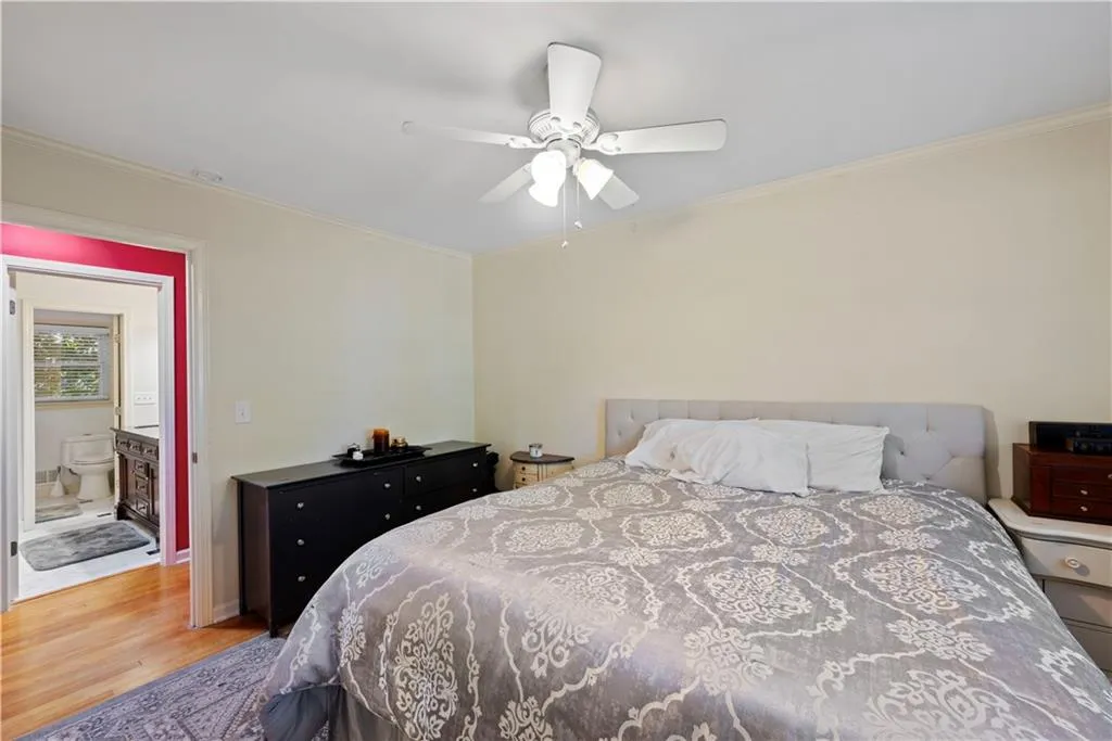 Bedroom featuring ornamental molding, wood finished floors, and a ceiling fan