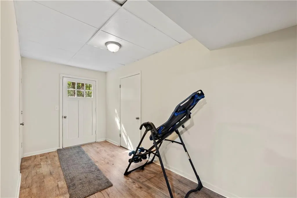 Exercise room featuring baseboards and light wood finished floors