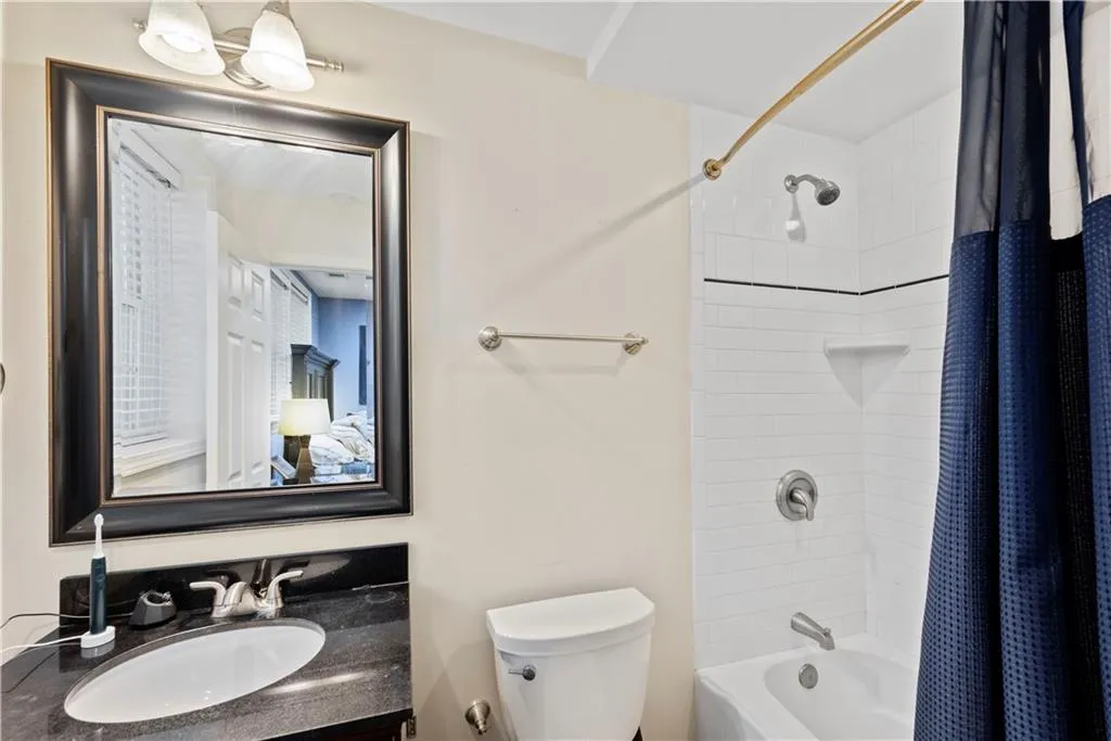 Full bathroom featuring shower / bath combo with shower curtain and vanity