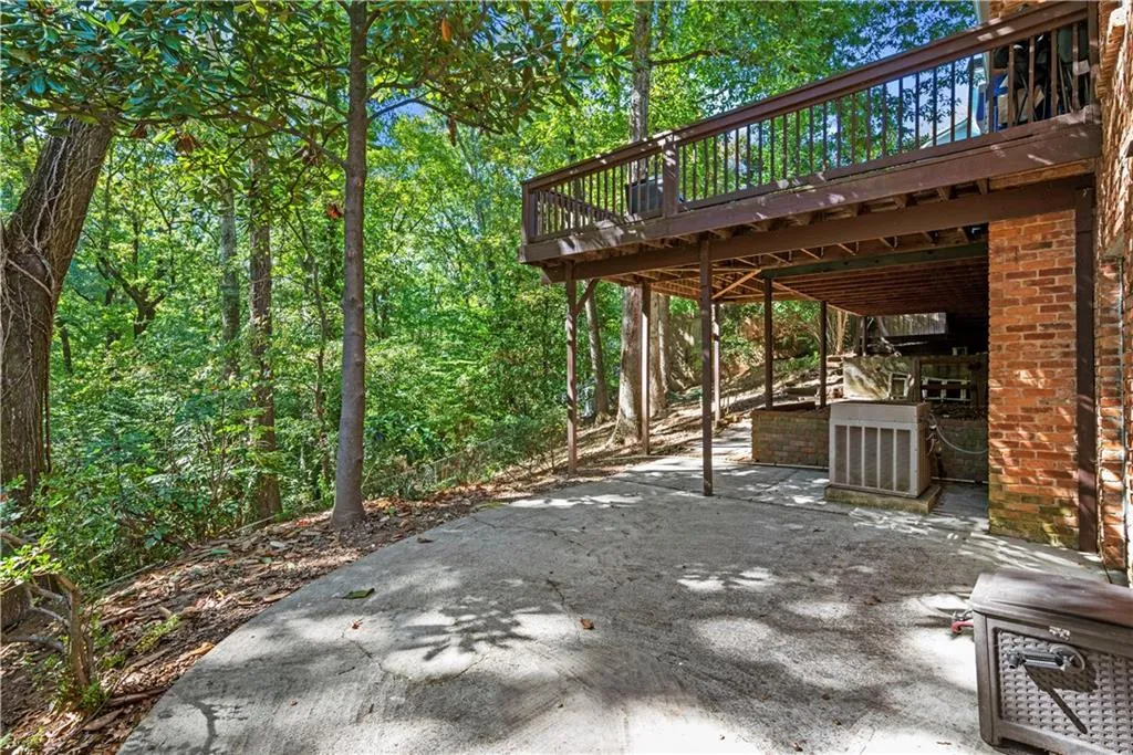 View of patio / terrace with a forest view and a deck