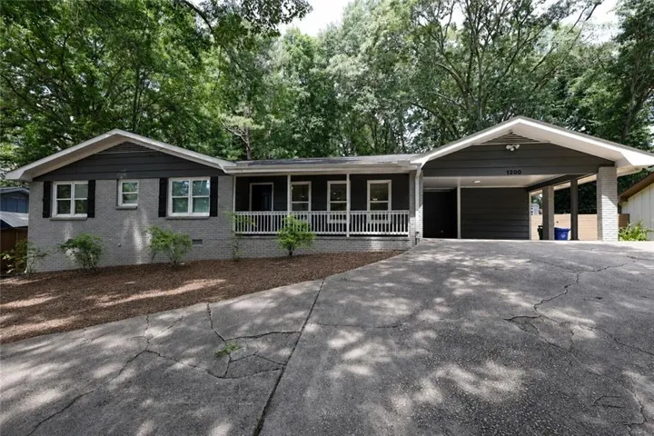 Single-story residence featuring a gray brick and siding exterior with white window frames and dark shutters