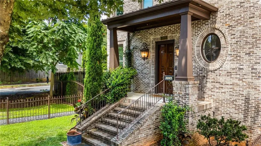 Brick exterior with a covered entry, wood-finish front door, and a prominent round window