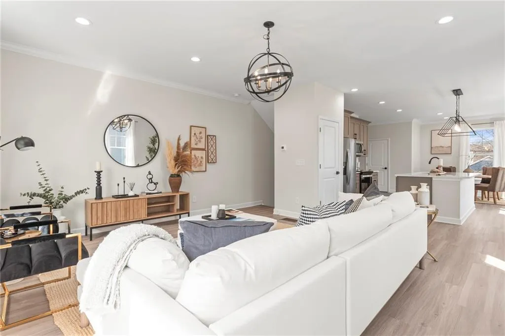 Living room featuring ornamental molding, recessed lighting, a chandelier, and light wood-type flooring