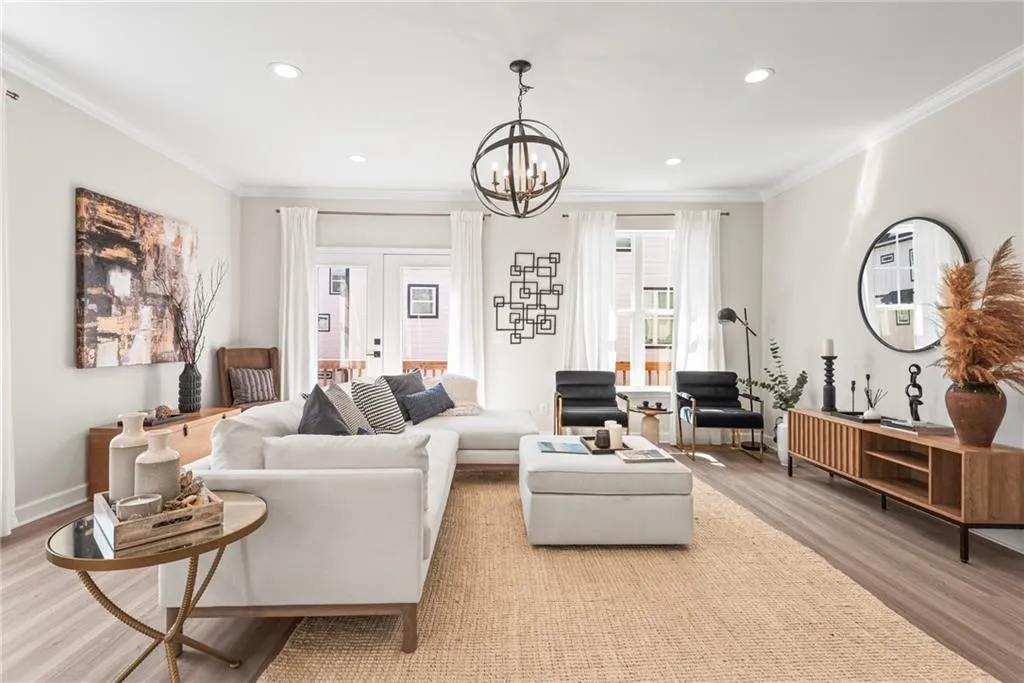 Living room featuring light wood-type flooring, ornamental molding, recessed lighting, french doors, and a chandelier