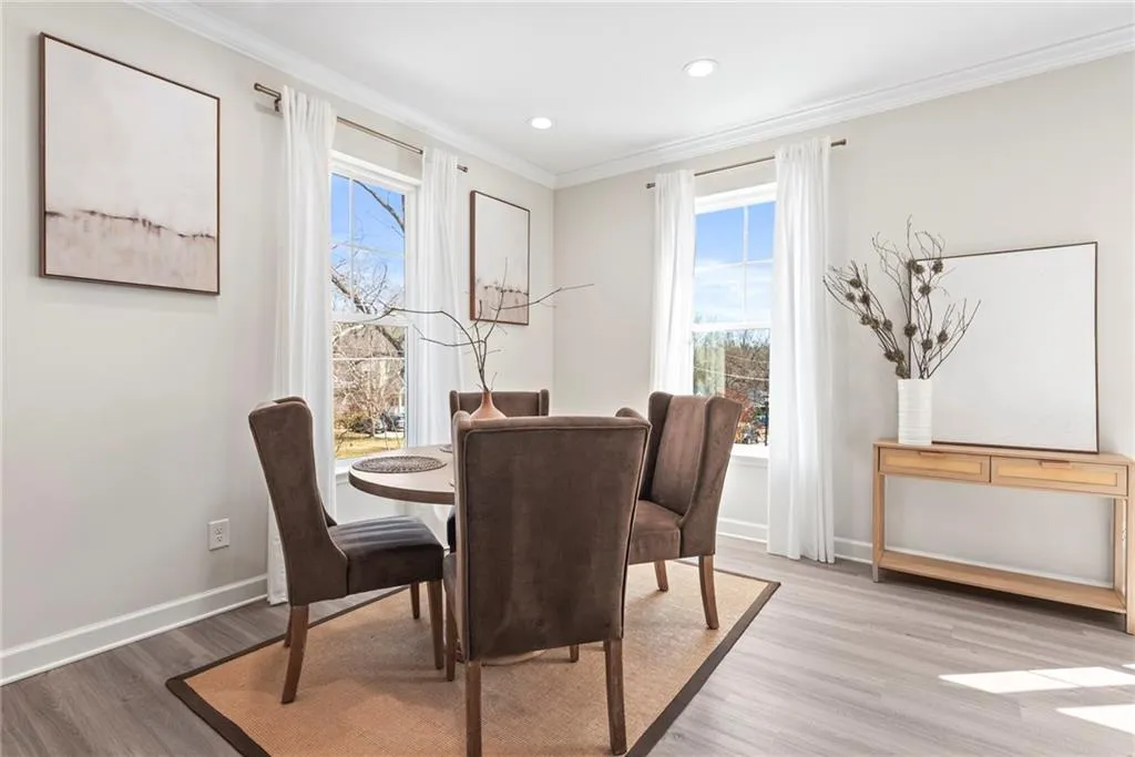 Dining room featuring crown molding, healthy amount of natural light, wood finished floors, and recessed lighting