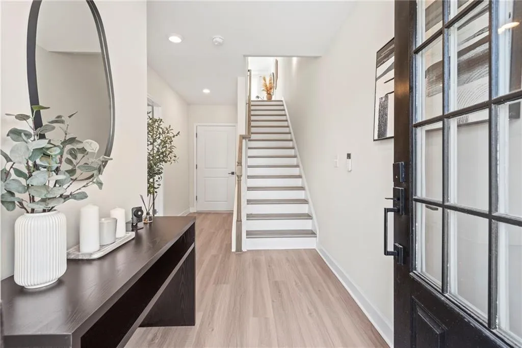 Foyer featuring light wood-style floors, stairs, and recessed lighting