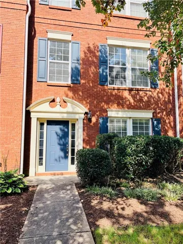 Brick exterior with white window trim and blue decorative shutters