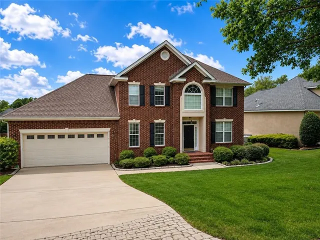 Brick exterior with black shutters and a white arched window