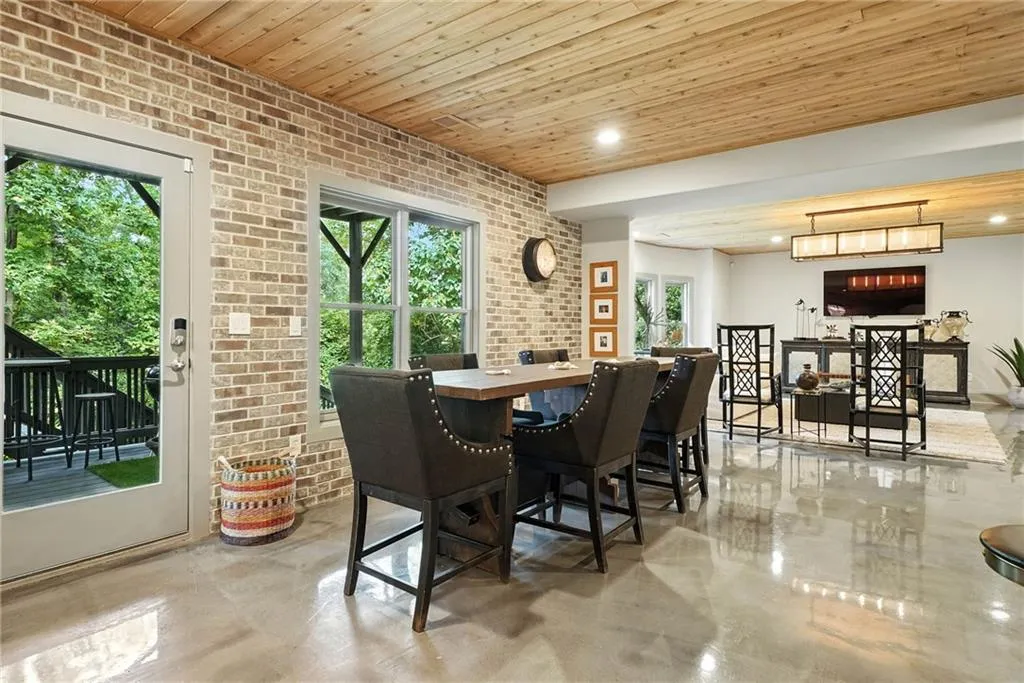 Dining room with brick wall, wood ceiling, and recessed lighting
