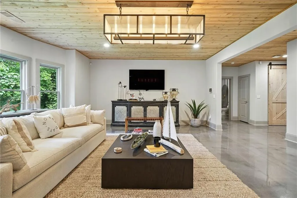 Living area with wood ceiling, a barn door, and finished concrete flooring