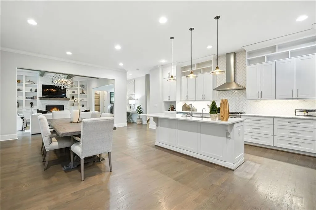 Kitchen with tasteful backsplash, decorative light fixtures, a stone fireplace, recessed lighting, and white cabinets