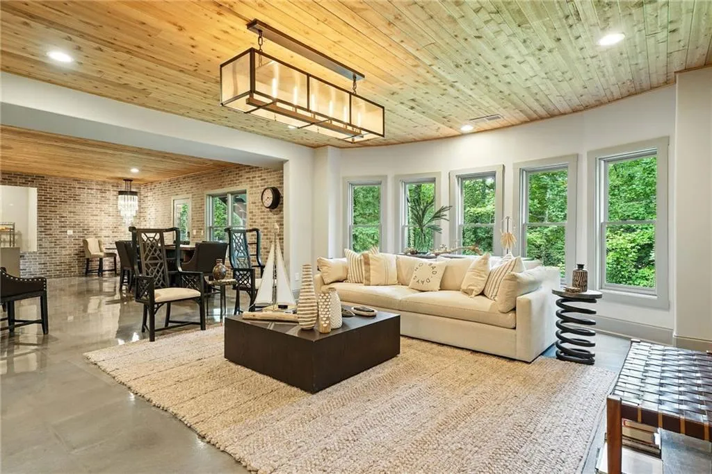 Living room featuring brick wall, wood ceiling, recessed lighting, and concrete floors