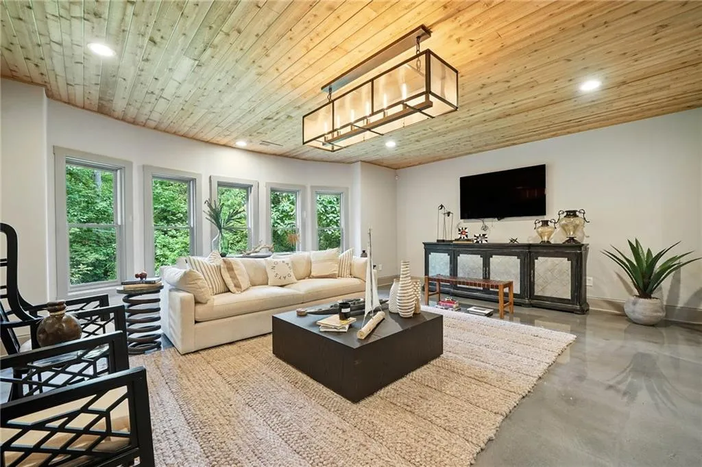 Living room featuring wooden ceiling, recessed lighting, and finished concrete flooring