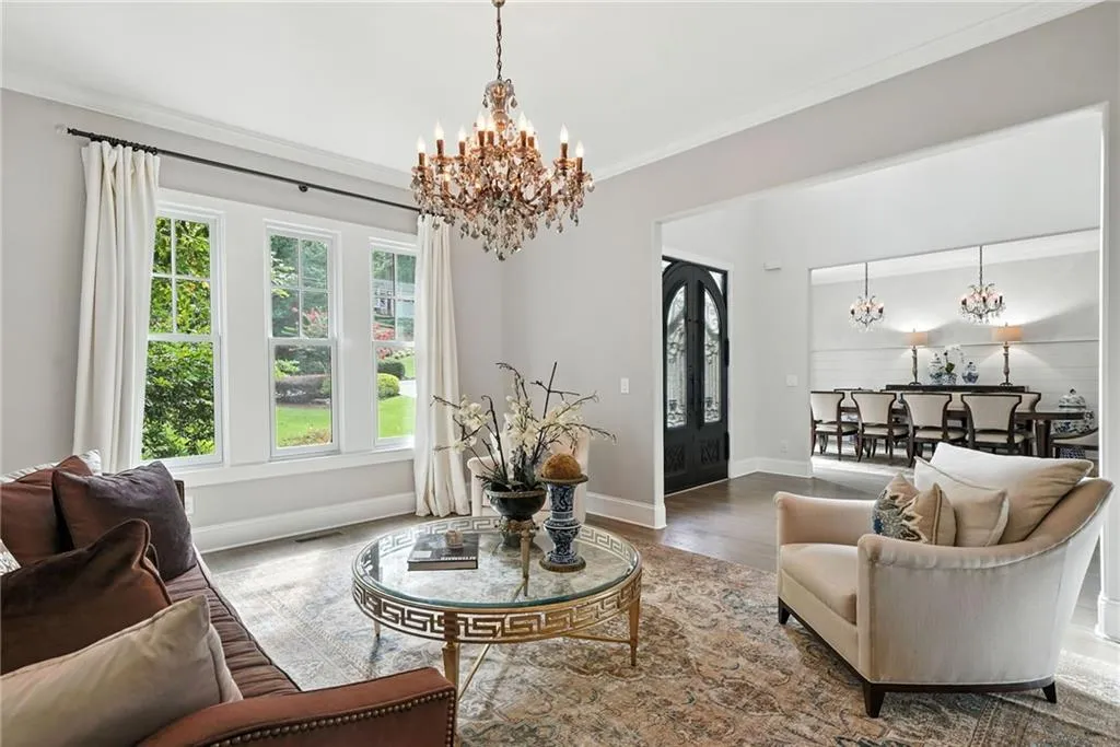 Living room featuring a chandelier, ornamental molding, and wood finished floors