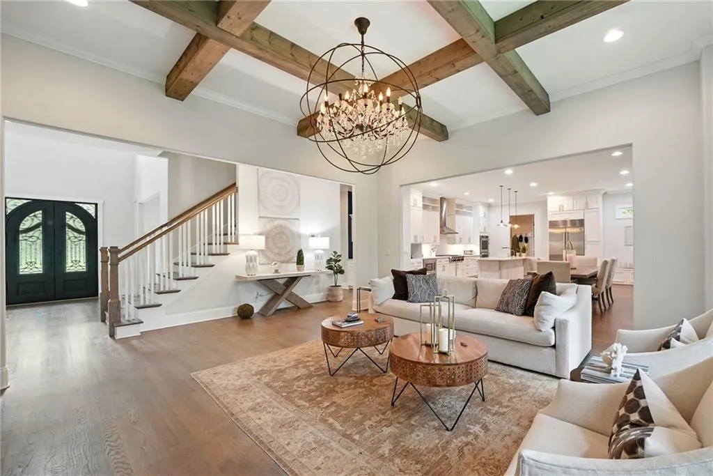 Living area with recessed lighting, beamed ceiling, wood finished floors, coffered ceiling, and french doors