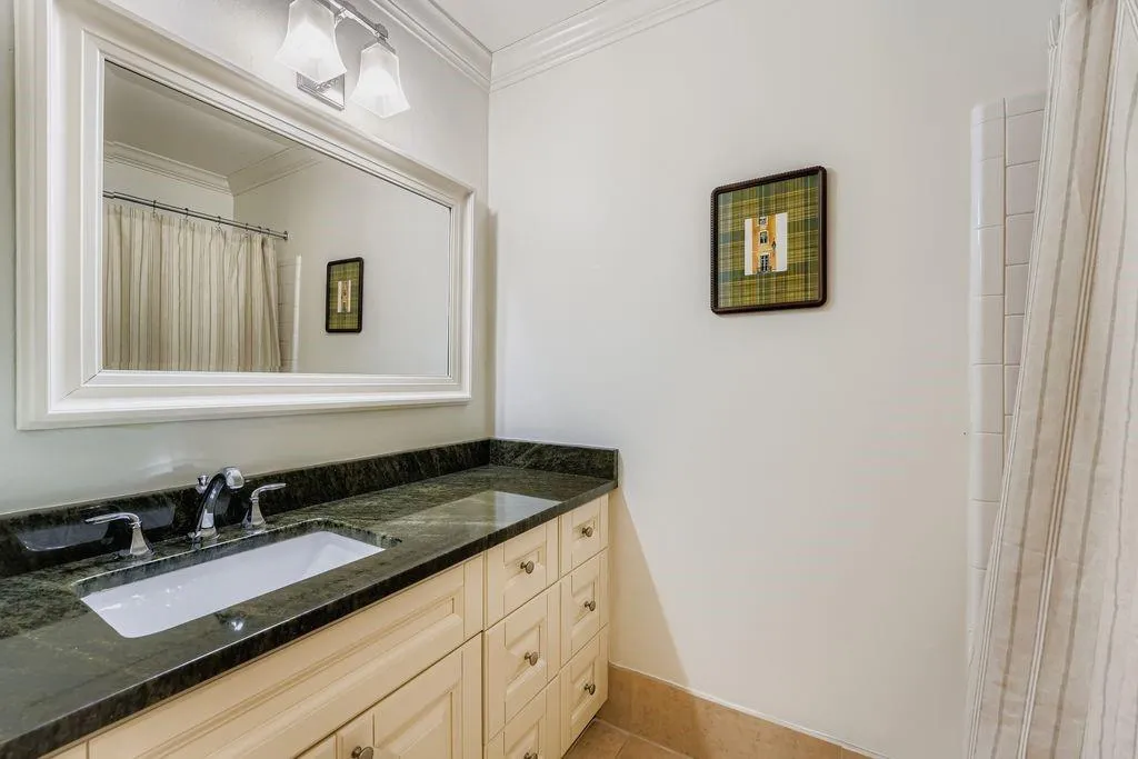 Bathroom featuring vanity, a shower with curtain, ornamental molding, and light tile patterned flooring Bathroom featuring vanity, a shower with curtain, ornamental molding, and light tile patterned flooring