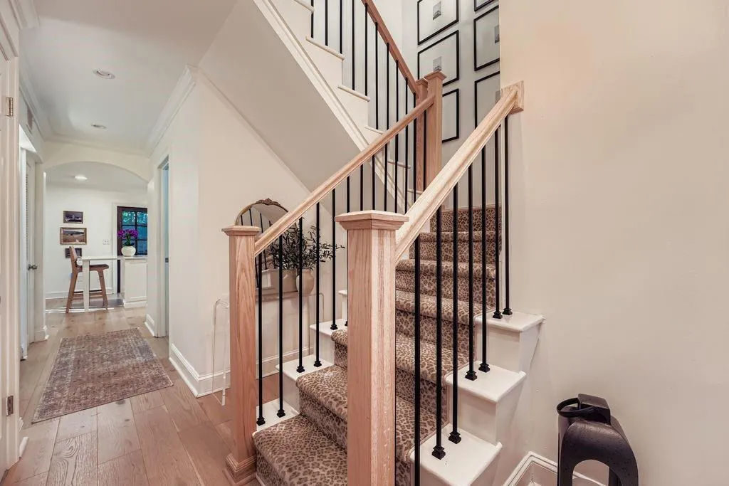 Stairs with arched walkways, hardwood flooring, and modern metal staircase spindles Stairs with arched walkways, hardwood flooring, and modern metal staircase spindles